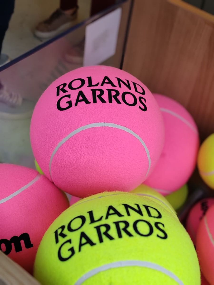 Pelotas de Roland Garros rosadas y amarillas en una canasta