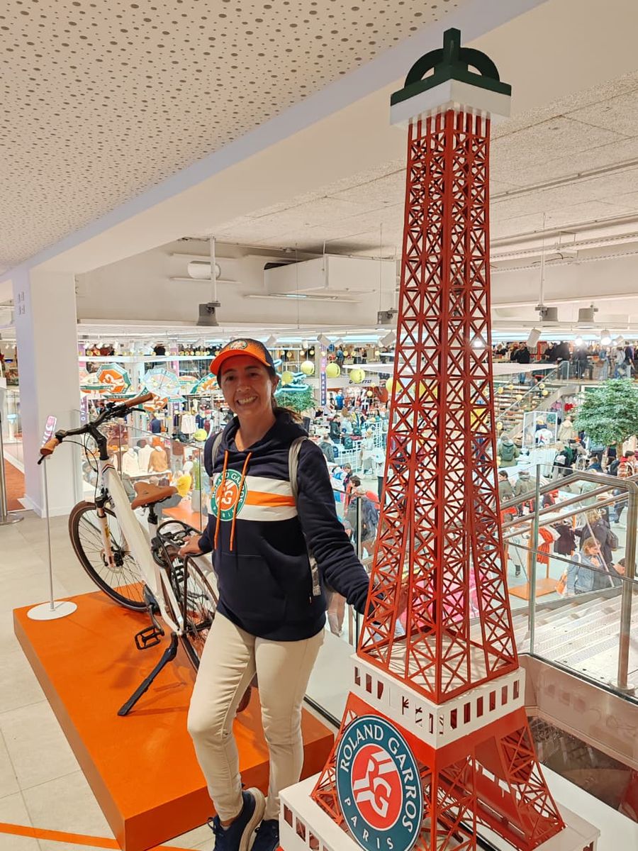 Mujer del grupo junto a una torre Eiffel decorativa en la tienda