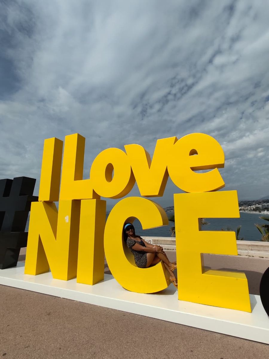 Mujer del grupo sentada en las letras de I Love Nice