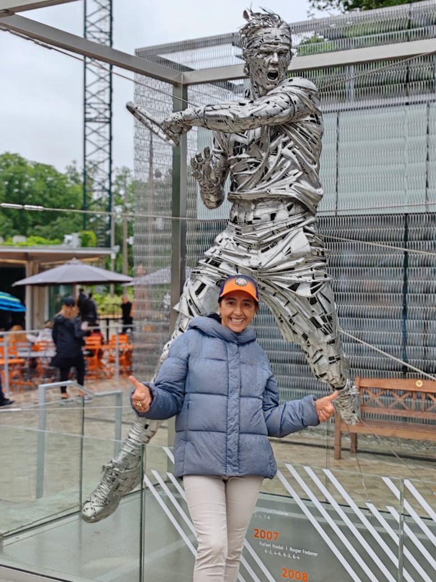 Mujer del grupo junto a la escultura metálica de un tenista