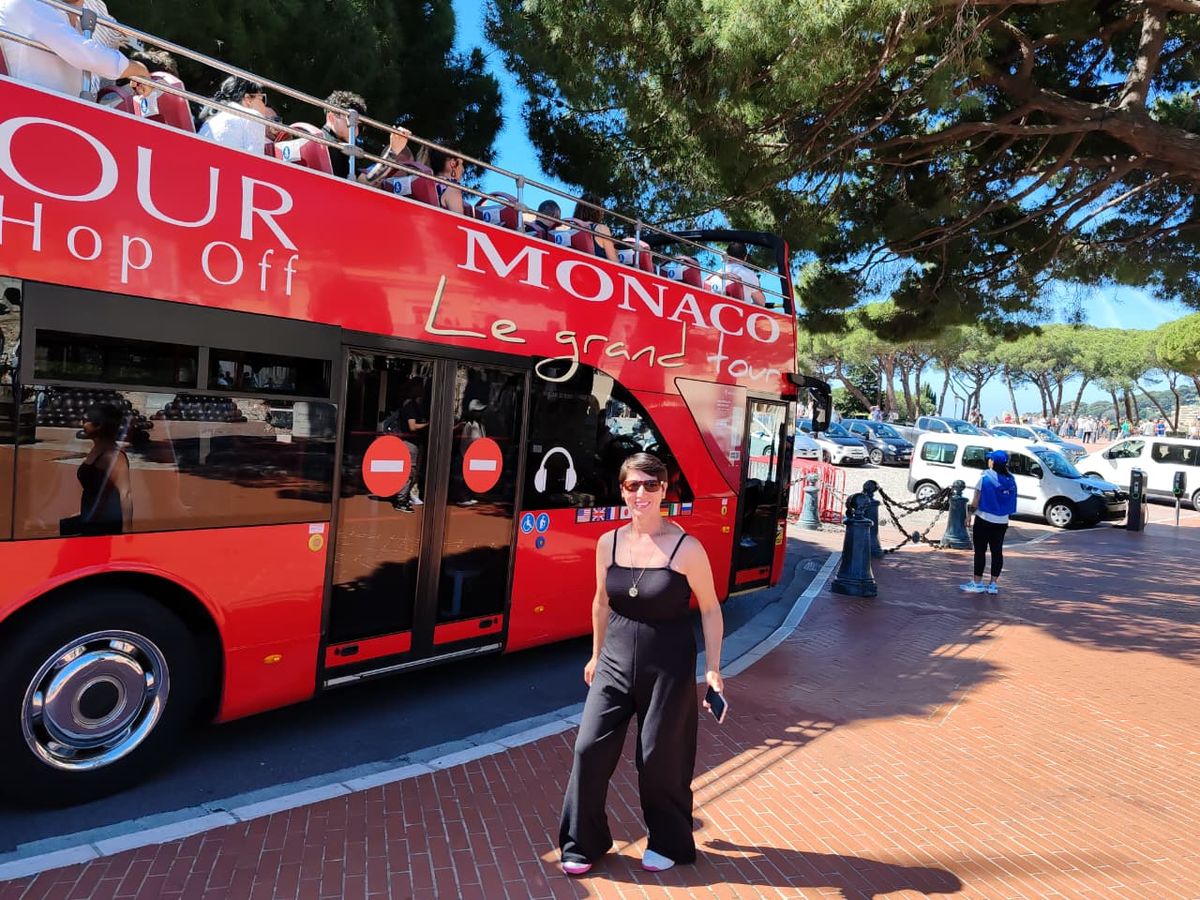 Mujer del grupo junto al bus turístico de Mónaco