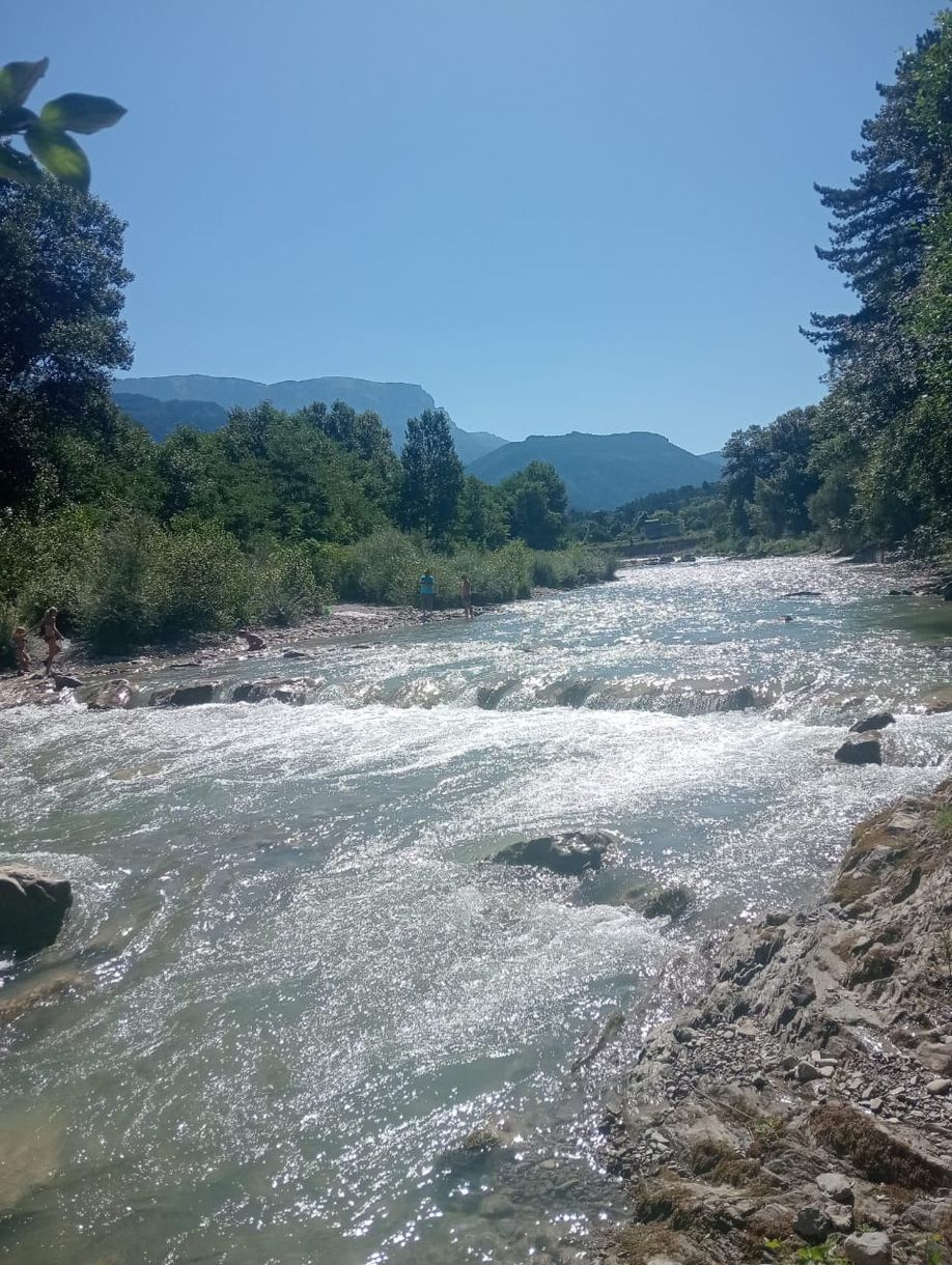 El río Drôme bajando entre las piedras con las montañas al fondo